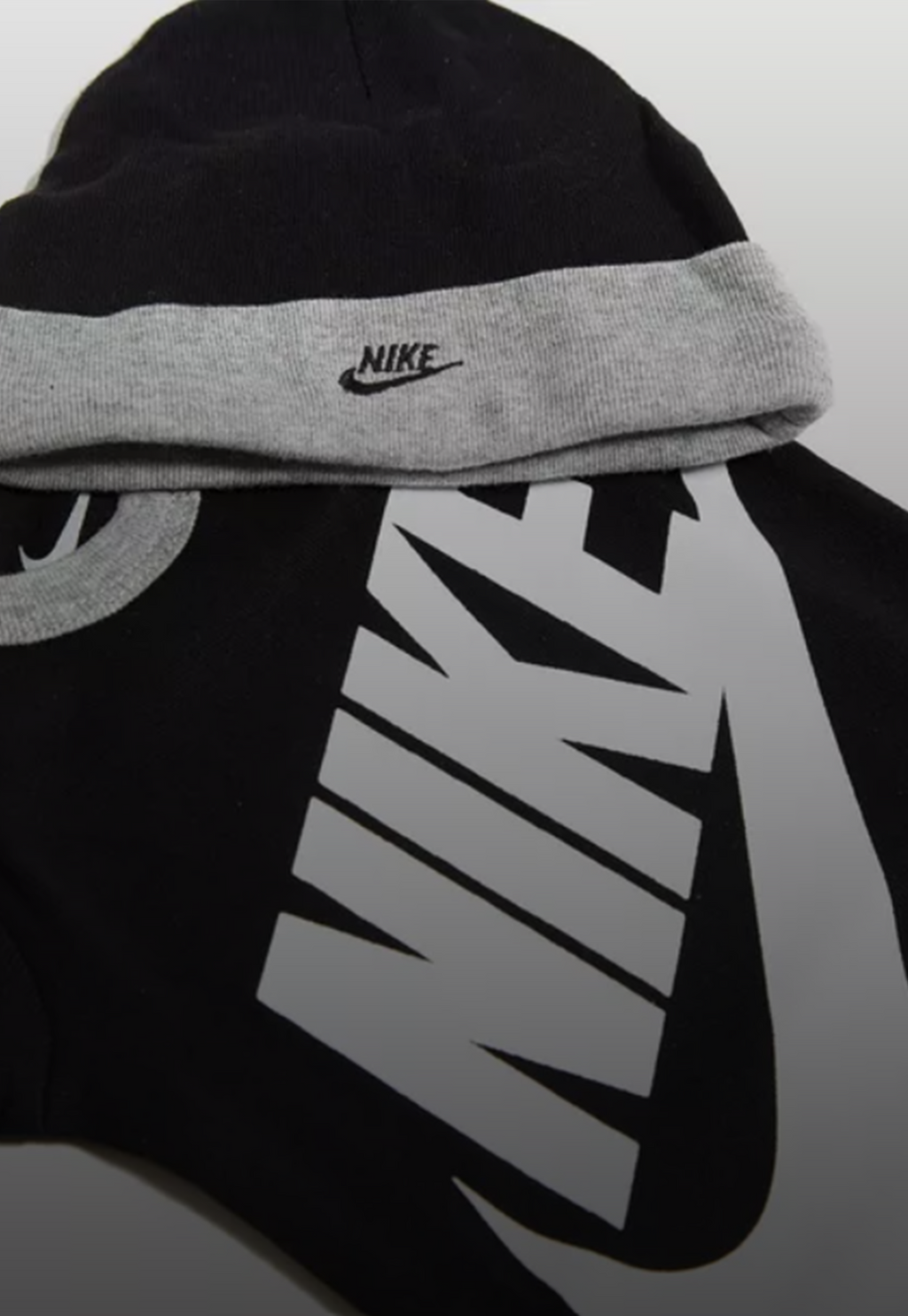 Nike set regalo neonato composto da 3 pezzi: body, cappellino e scarpine in cotone. Colorazione nero, grigio e bianco