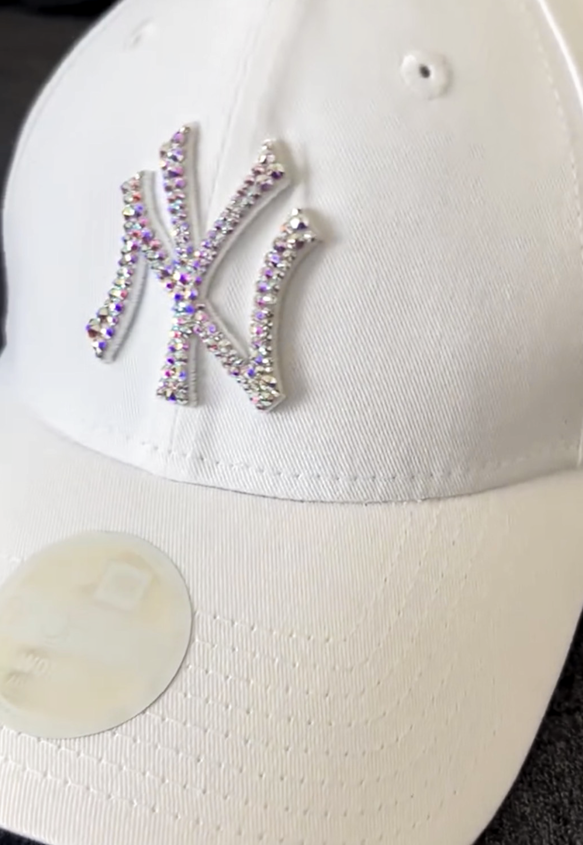 Acquista il cappello New Era NY Yankees personalizzato con brillantini color aurora cangianti: un accessorio esclusivo, glamour e streetwear, perfetto per look originali e idee regalo. Colore Cappello: Bianco