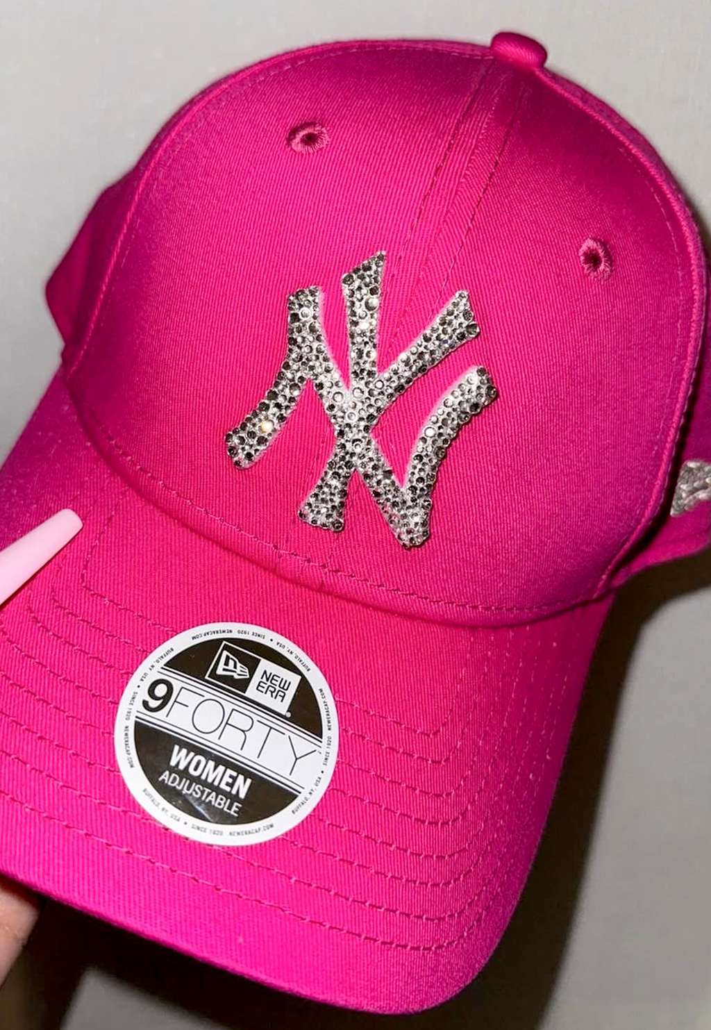 Acquista il cappello New Era NY Yankees personalizzato con brillantini color argento: un accessorio esclusivo, glamour e streetwear, perfetto per look originali e idee regalo. Cappello Colore Fucsia