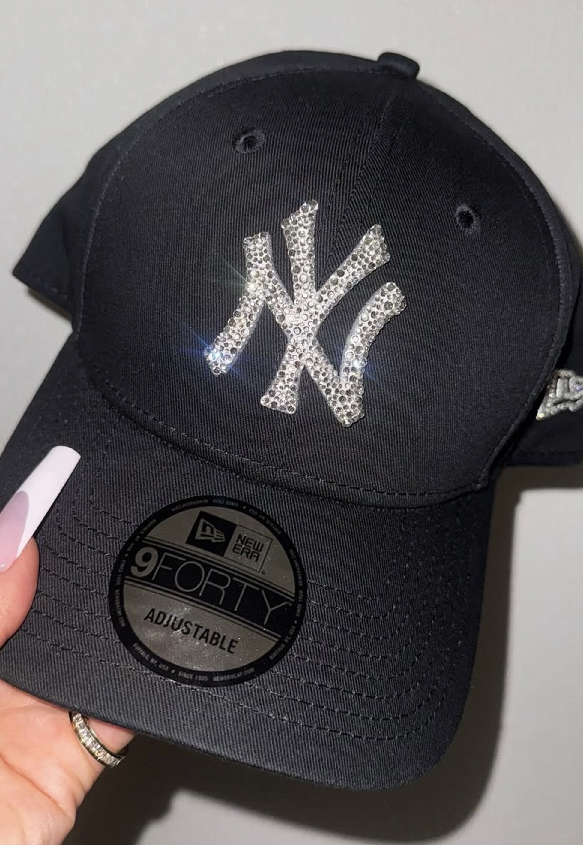 Acquista il cappello New Era NY Yankees personalizzato con brillantini color argento: un accessorio esclusivo, glamour e streetwear, perfetto per look originali e idee regalo. Cappello Colore Nero