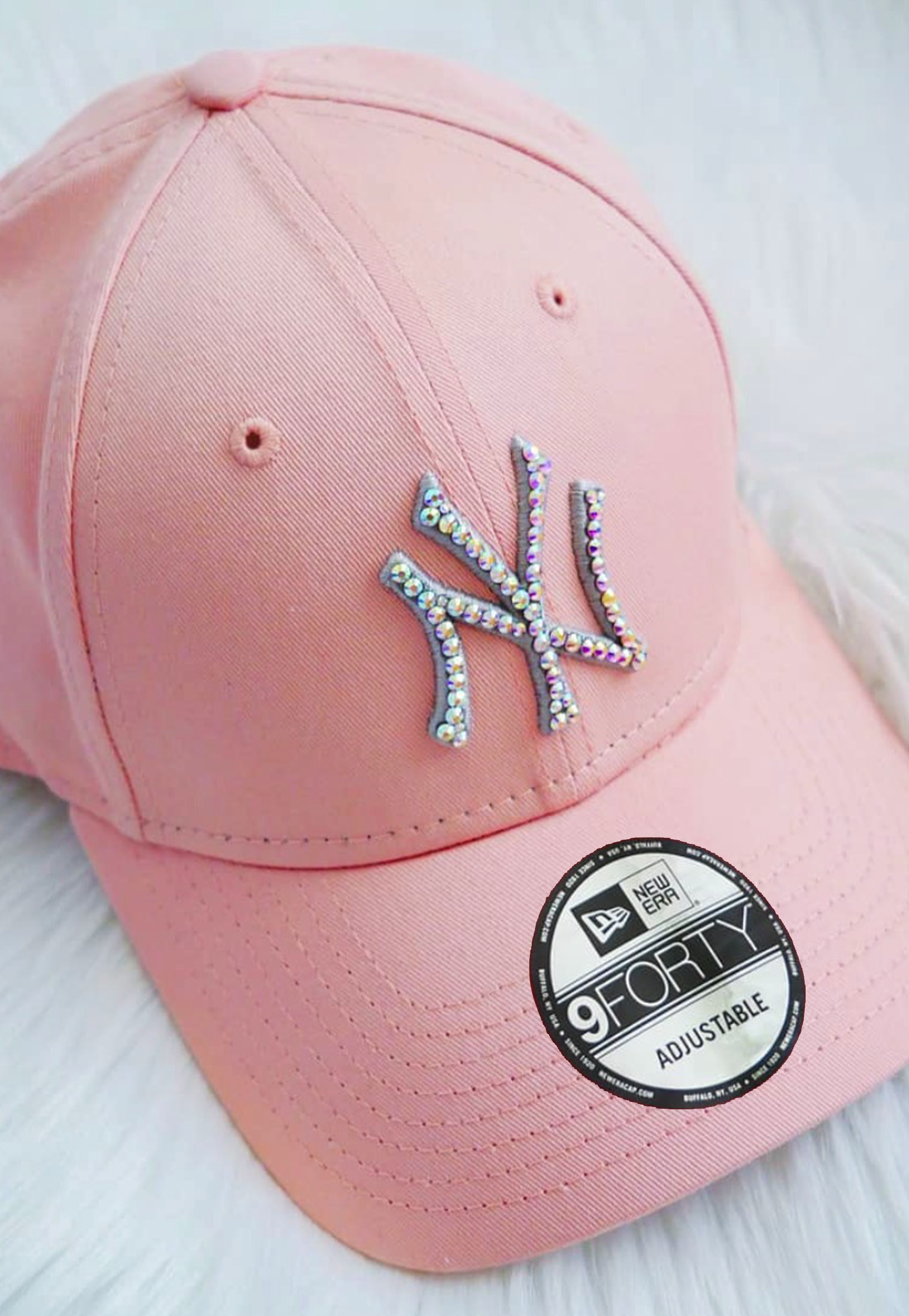 Acquista il cappello New Era NY Yankees personalizzato con brillantini color aurora cangianti: un accessorio esclusivo, glamour e streetwear, perfetto per look originali e idee regalo. Colore Cappello: Rosa 